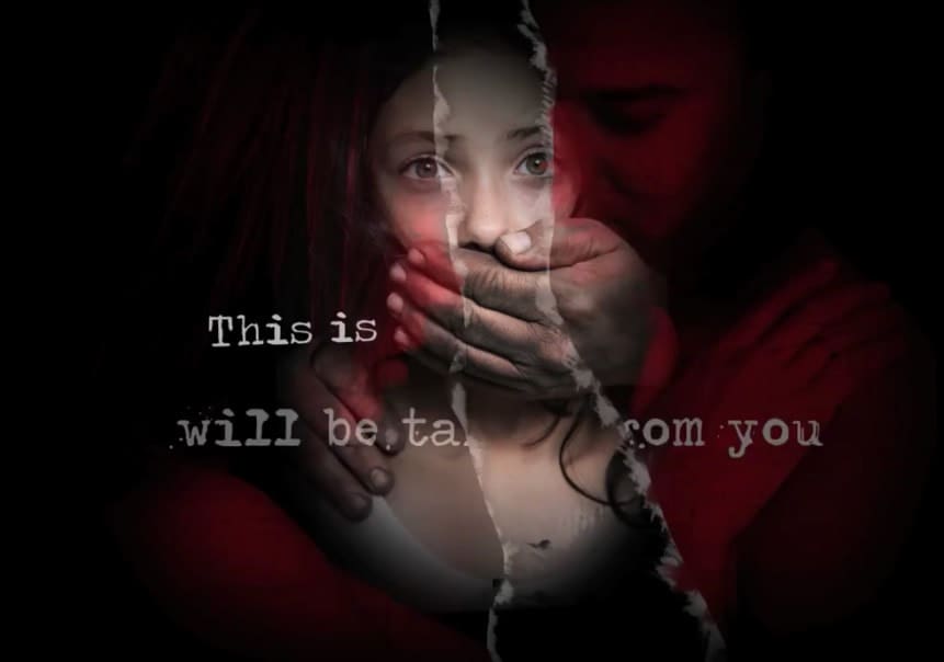 A woman is holding her mouth open and a man is behind her.