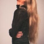 Woman laughing with long hair, profile view.