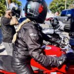 Motorcyclist in helmet on red Ducati bike.